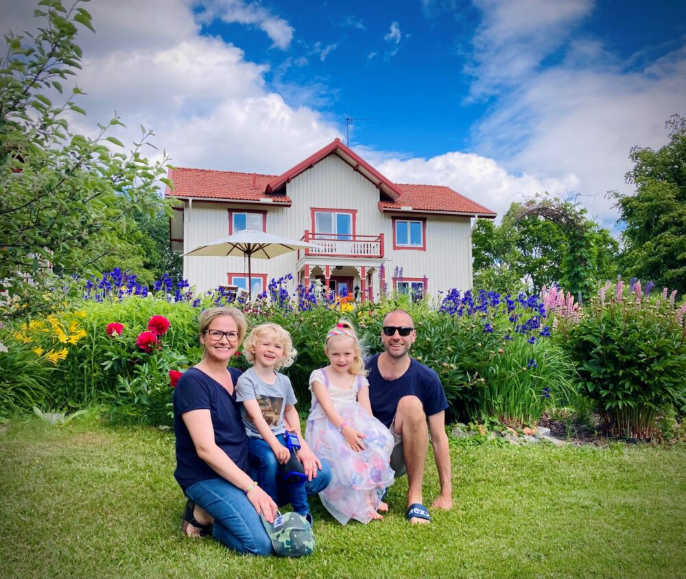 Här är familjen som lämnade en trea i Täby för en Hälsingegård i Edsbyn “Allt vi behöver finns här” Sara från Sundsvall och Anders från Vallentuna hade byggt ett liv med två barn, bra jobb och nybyggd lägenhet i Täby. Men plötsligt bröt makarna Rylander upp. Mitt i livet sålde de trean i Täby och köpte en 200-kvadrats Hälsingegård i Roteberg, utanför Edsbyn. “Vi tyckte det var så fint här”, säger Sara skrattandes som svar på den självklara frågan: Varför? Det var vid ett besök hos släktingar i Edsbyn idén föddes. “Om ni hör nåt fint hus som blir till salu så berätta för oss, sa vi. Lite på skoj och lite på allvar. Det var ju så fint och rofyllt här i Hälsingland jämfört med där vi bodde då.” Samtalet kom snabbare än paret kunnat ana. “Det var en större gård som skulle säljas om ett år. Vi åkte upp och kikade i mörkaste november. Det var grått och trist. Sen gick vi in i köket, och där blev vi fast. Det här köper vi, sa vi i munnen på varandra”, berättar Sara. Så med två barn - ett bara tre veckor gammalt - valde Sara att lämna en trygg universitetsanställning och Anders ett butikschefsjobb i huvudstaden för en flytt till Hälsingland. “Vi bestämde oss för att den som först fick jobb skulle ta det. Den andra skulle vara föräldraledig”. Sara fick jobb ganska omgående. Jobbet som kommunsekreterare på på Ovanåkers kommun var riktigt roligt. Men… “Jag läste en artikel i Dagens Industri om mjukvaruföretaget MTEK I Alfta. Vi pratar alltså ett riktigt högteknologiskt företag här i Hälsingland. Det var så fascinerande att nån orkar stå emot Stockholmskoncentrationen att jag sökte mig dit direkt”, berättar Sara som i dag är Chief of Staff på MTEK. För Anders gick det trögt till en början. “Utan nätverk är det inte lätt att komma in. Jag jobbade en sväng med skogs- och fastighetsförvaltning innan jag fastnade för en annons för butikschef för Rusta i Söderhamn.” I dag pendlar han tvärs genom Hälsingland för att jobba med det han vill. “Jag jobbar med ett väldigt bra gäng. Det underlättar pendlingen”, säger Anders. Han funderar en stund och fyller i: “Samtidigt tar det mig lika lång tid att åka till jobbet i dag som det gjorde i Stockholm. Här slipper man köerna.” Det kan låta drastiskt att bryta upp tillvaron i fina lägenheten i Täby för ett oprövat äventyr i Hälsingland. Men varken Sara eller Anders ångrar steget ens en sekund. “Vi sålde lägenheten och köpte det här för över en miljon mindre”, säger paret och sveper ut med blicken över gårdstunet. Utsikten är slående, med grönskande ängar, en prunkande och välplanerad trädgård och ett bostadshus på över 200 kvadrat. Intill ligger en nästan lika stor byggnad, med bakstuga och en planerad gästlägenhet. “Vi kan inte bo bättre”, säger Anders. “Vi flyttade hit för att ge barnen möjlighet att växa upp i denna fantastiska miljö. Vi älskar Stockholm, men det här alltså… Vi kunde inte ha fått det bättre”, säger Sara och fortsätter: “Här har jag ett superspännande jobb i en global miljö, samtidigt som jag har skidspår, slalombacke, ridhuset, fotbollen och skogen inom fem minuter. Det är en perfekt balans mellan jobb och livskvalité.”